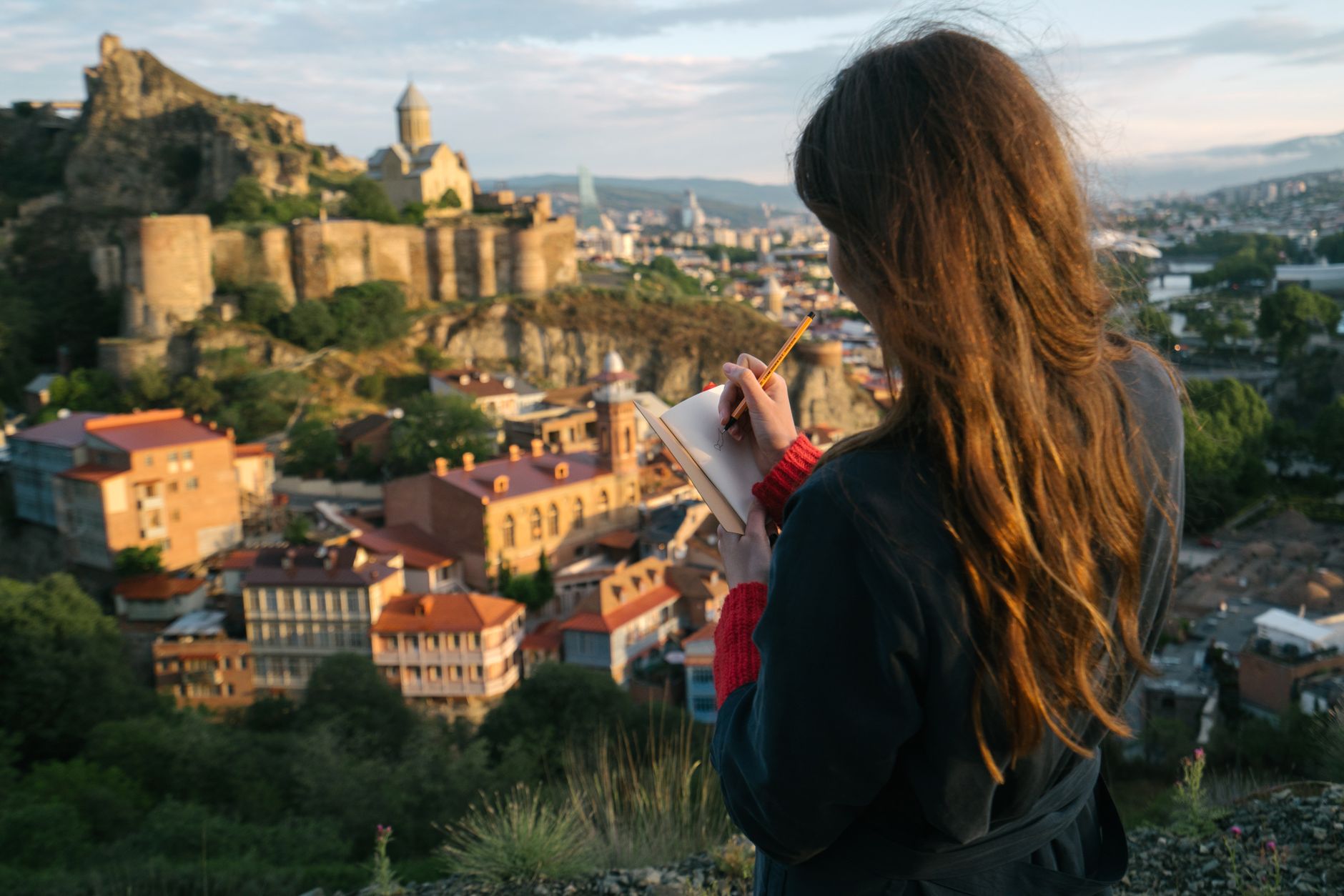 Travel writer documenting landscape in journal