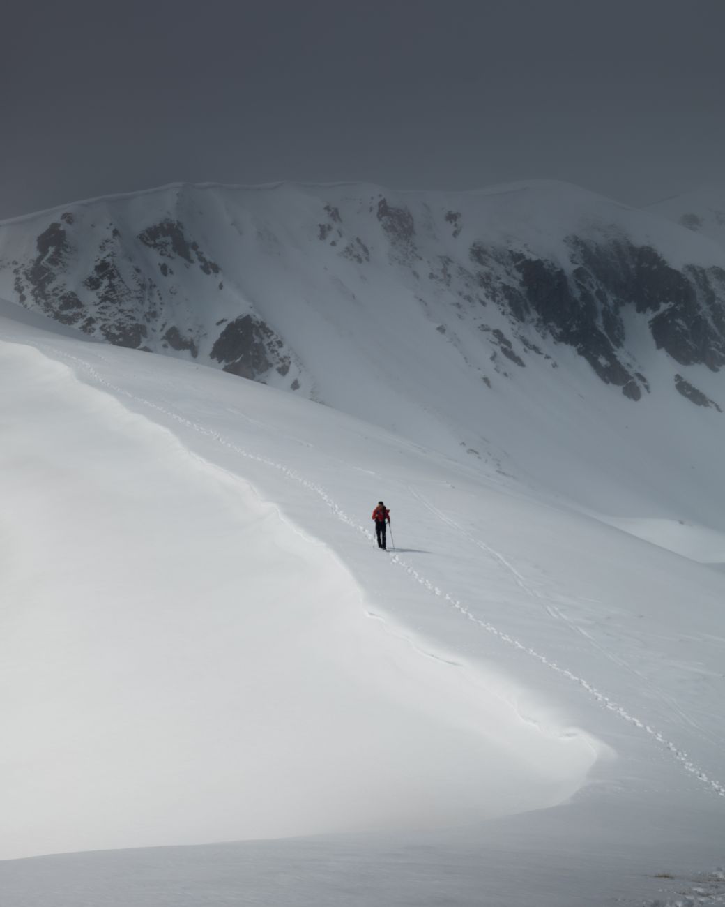 Backpacker walking softly along mountain meadow ridge
